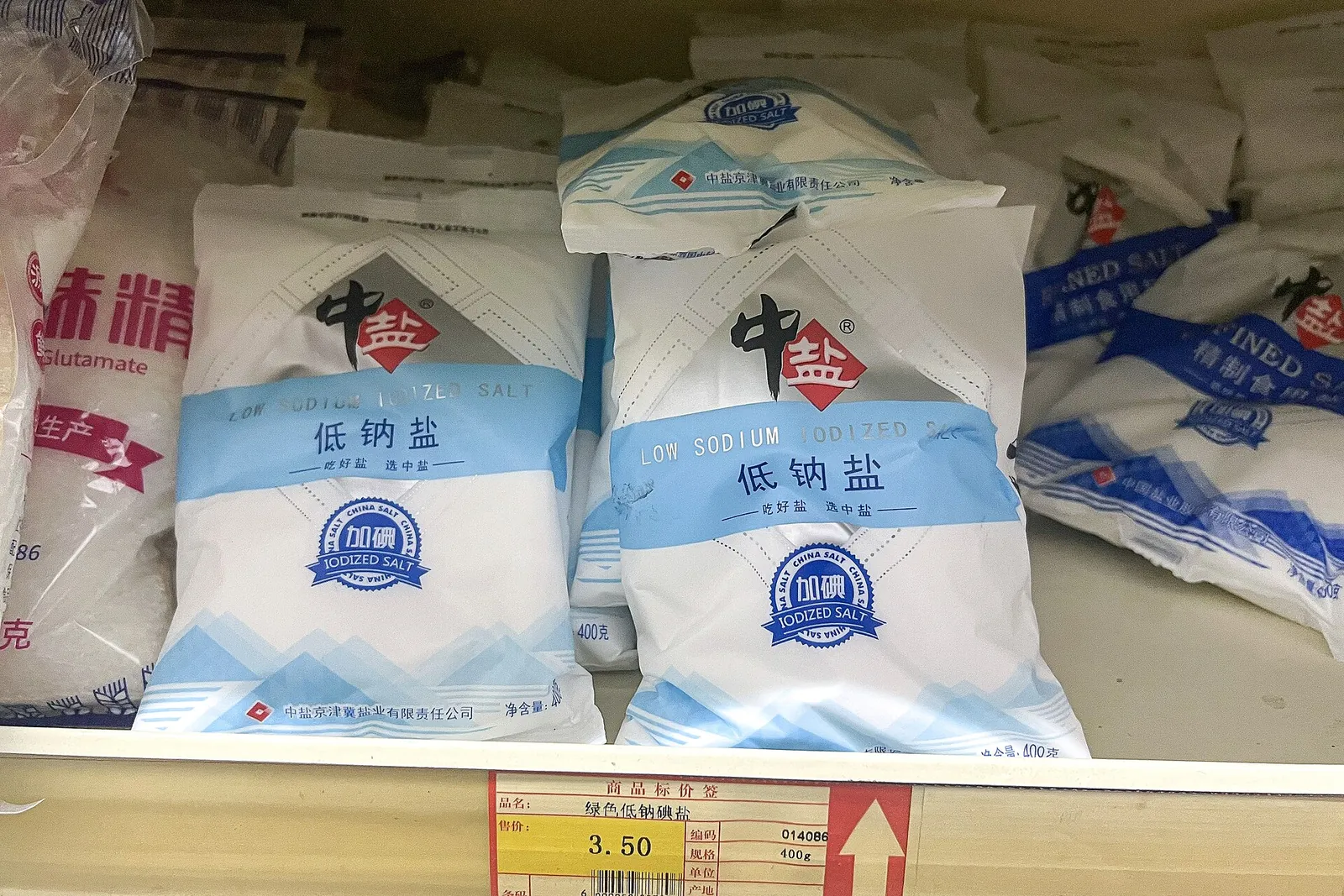 Bags of low-sodium iodized salt on a shop shelf in China, priced at 3.50 yuan.