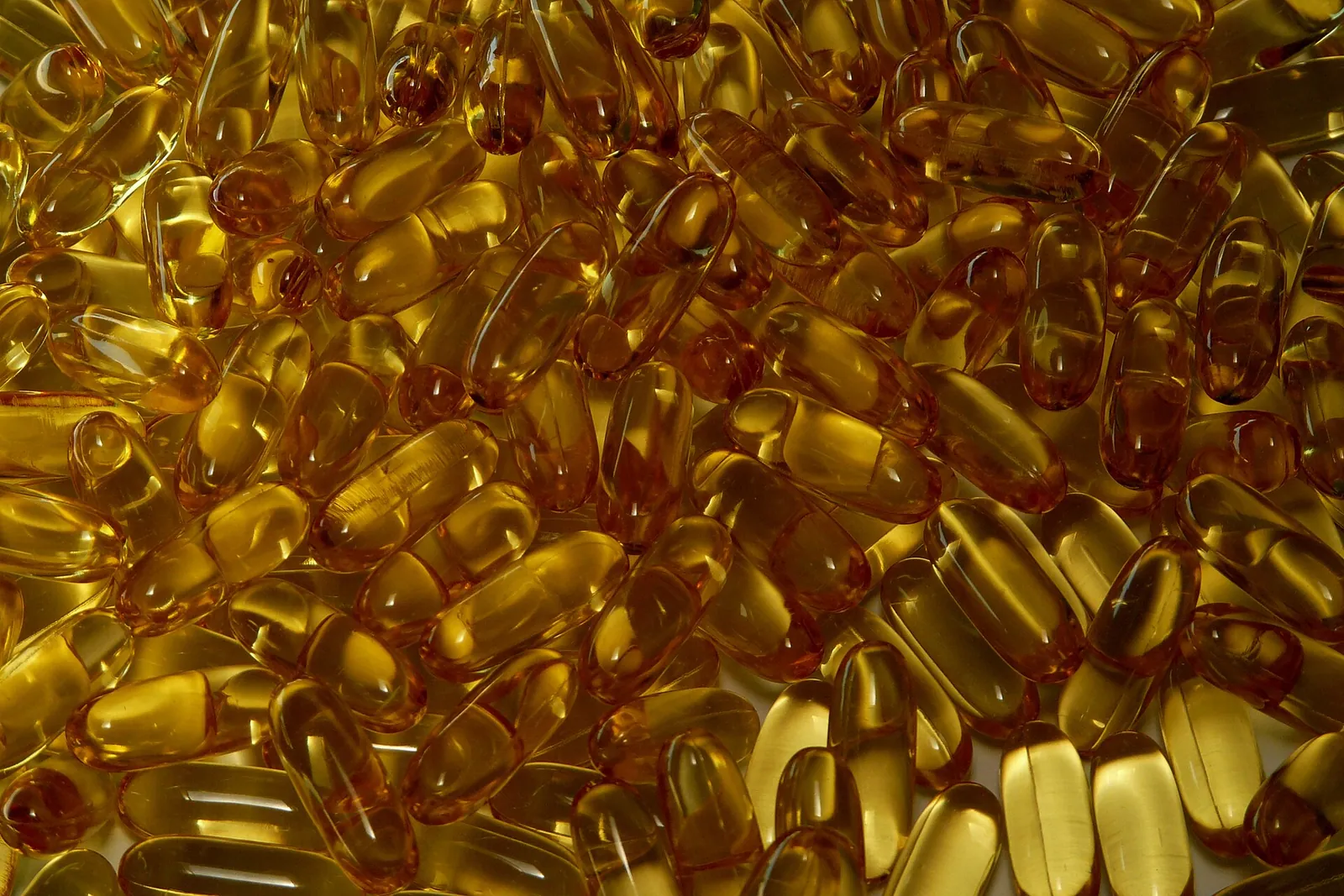 A heap of amber fish-oil capsules.