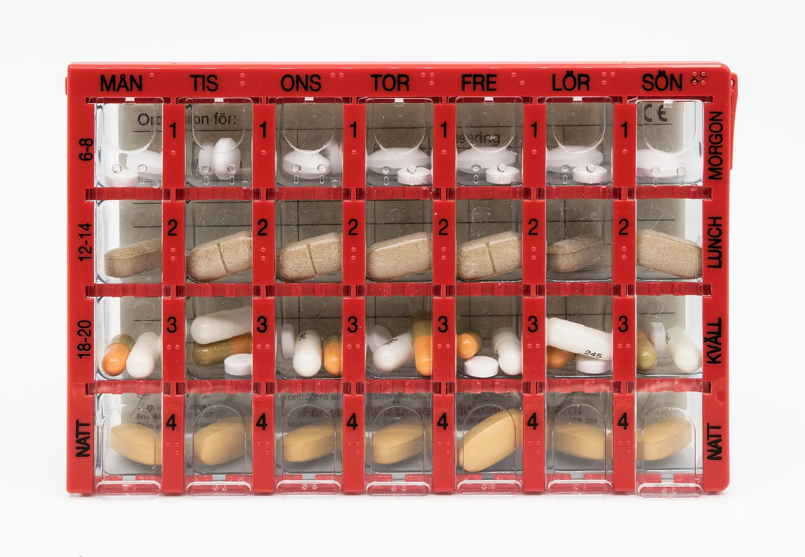 A weekly pill organiser with a compartment for each day and each time of day, filled with tablets.