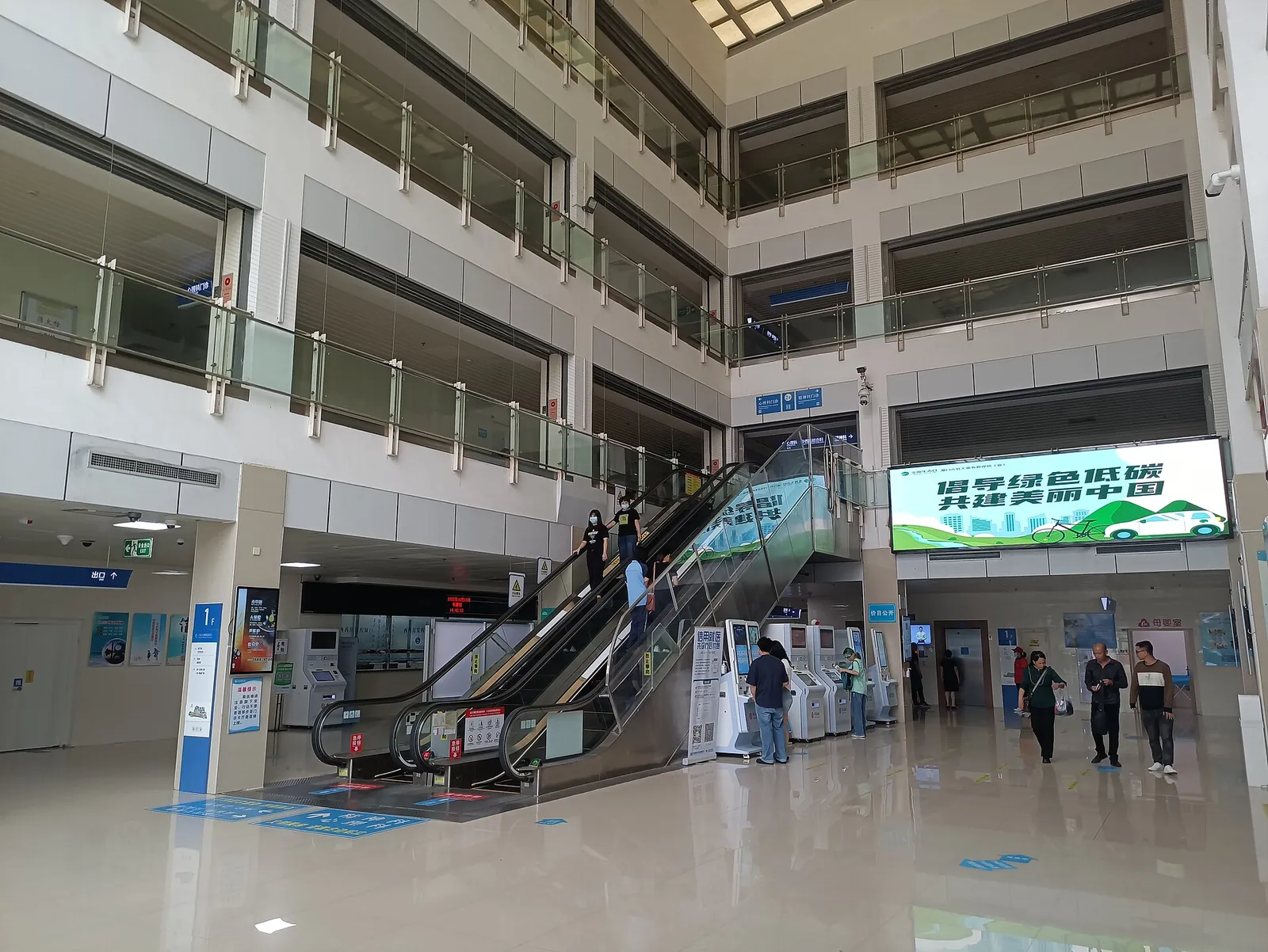The outpatient hall of a hospital in Xiamen, with escalators, service counters and self-service machines.
